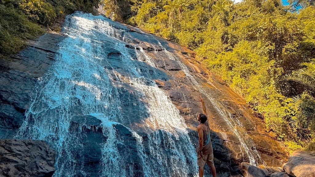 Visitante apontando para a queda da Cascata do Galo, em Domingos Martins